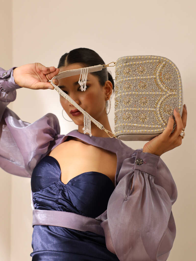 Grey Kavya flap-over bag with handle from The Tan Clan, showing front view with flap closure and top handle.
