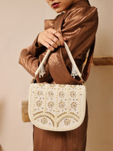 White flap-over bag with handle from The Tan Clan, stylish accessory featuring beige accents and spacious interior.