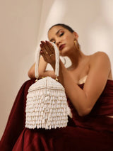 White round embellished bag with handle by The Tan Clan, featuring intricate detailing and a stylish design.