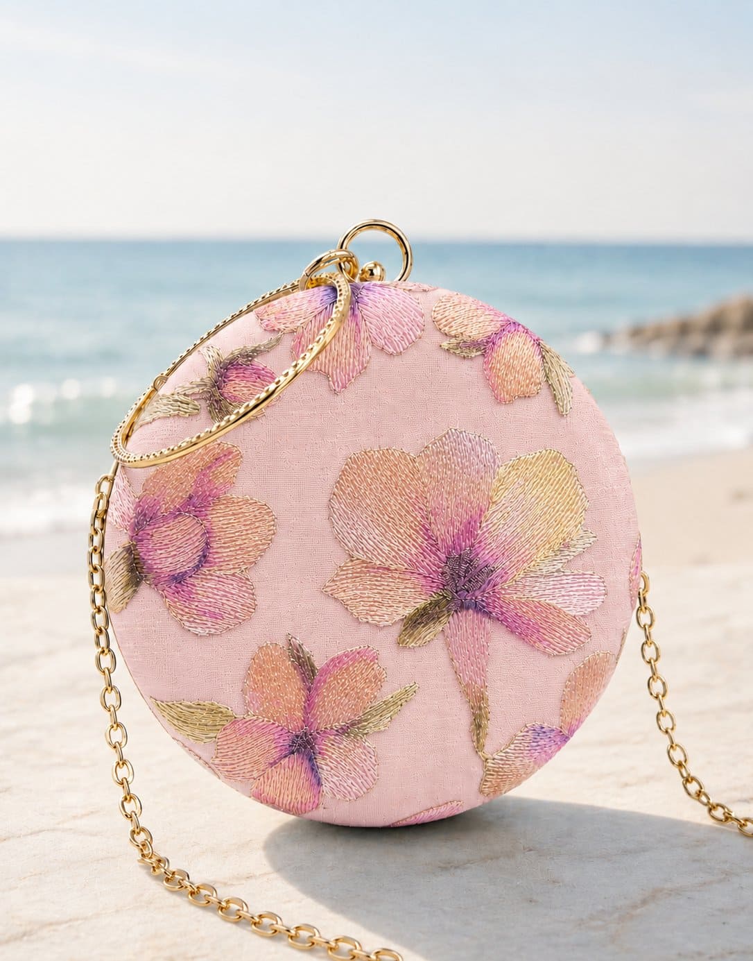 Pink embroidered clutch bag by The Tan Clan featuring floral embroidery and compact design for elegant occasions.