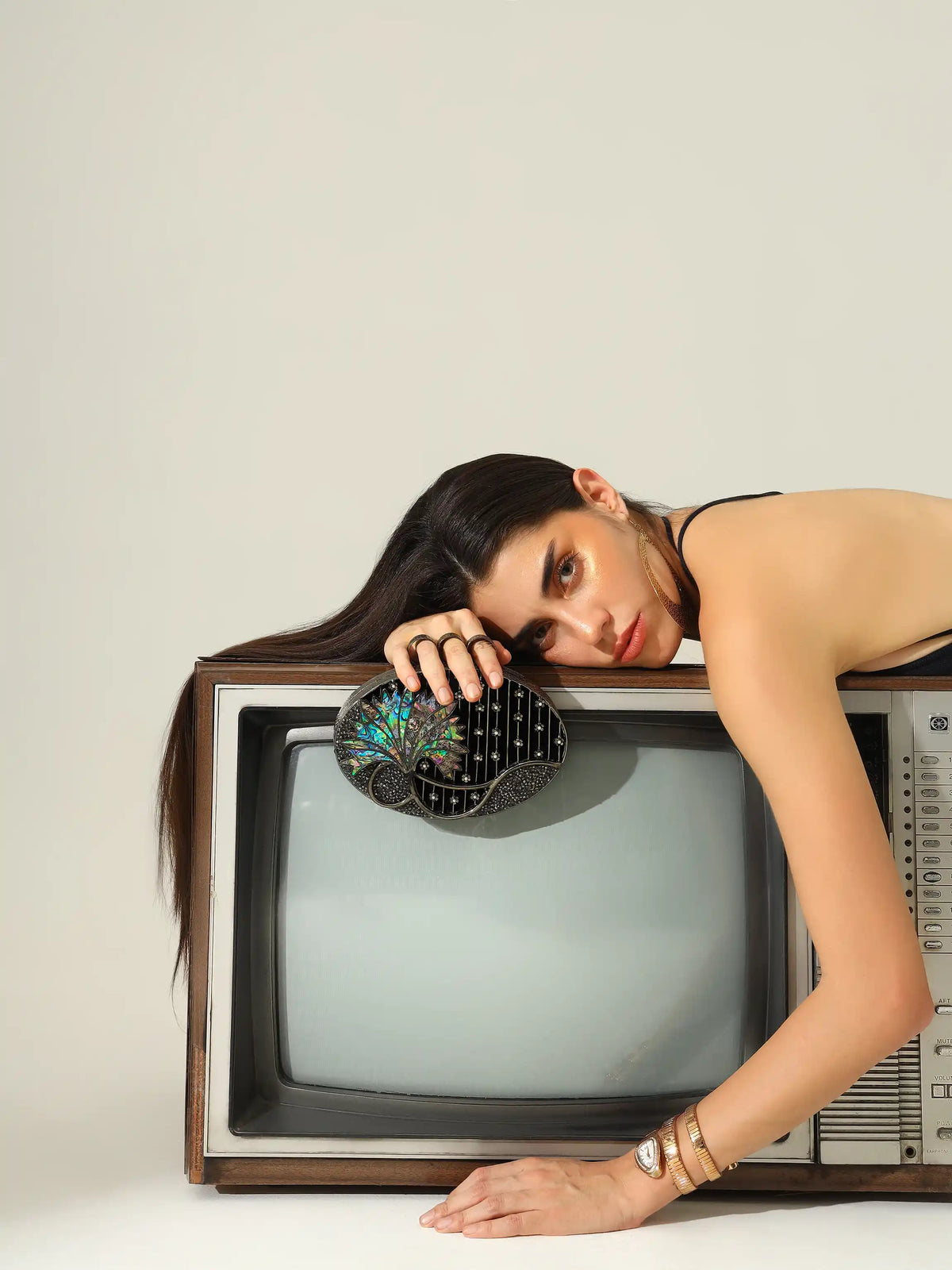 Nina Brass Clutch by The Tan Clan featuring a sleek, metallic design with a fold-over flap and minimalist style.