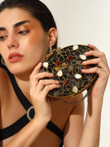 The Tan Clan Rhea Brass Clutch featuring a sleek, shiny brass finish and minimalist design for elegant evening use.