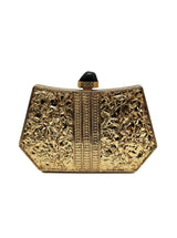 The Tan Clan Ruth Wired Brass Clutch showcasing a sleek brass design with a textured surface and elegant wrist strap.