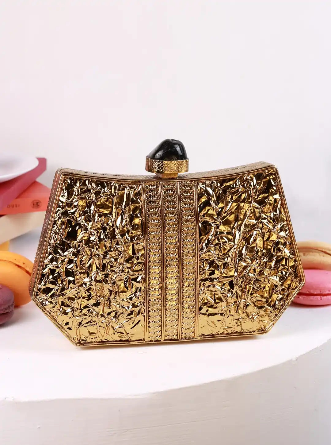 The Tan Clan Ruth wired brass clutch with a sleek design, featuring a textured brass finish and a compact shape.