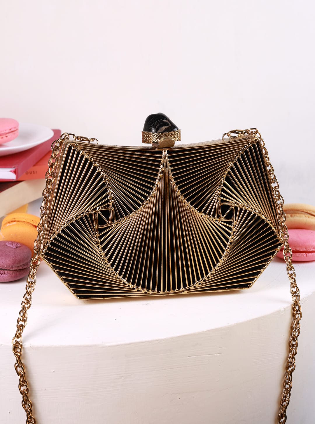 Ruth wired brass clutch by The Tan Clan featuring a sleek, structured design with metallic brass finish.