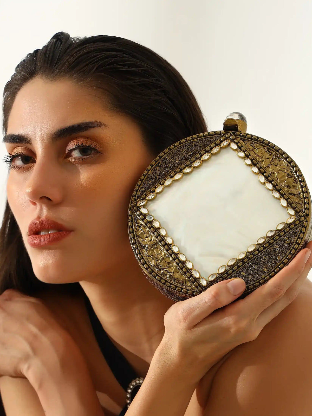 Seren Brass Clutch by The Tan Clan showing a sleek brass clutch with a smooth finish and elegant design.