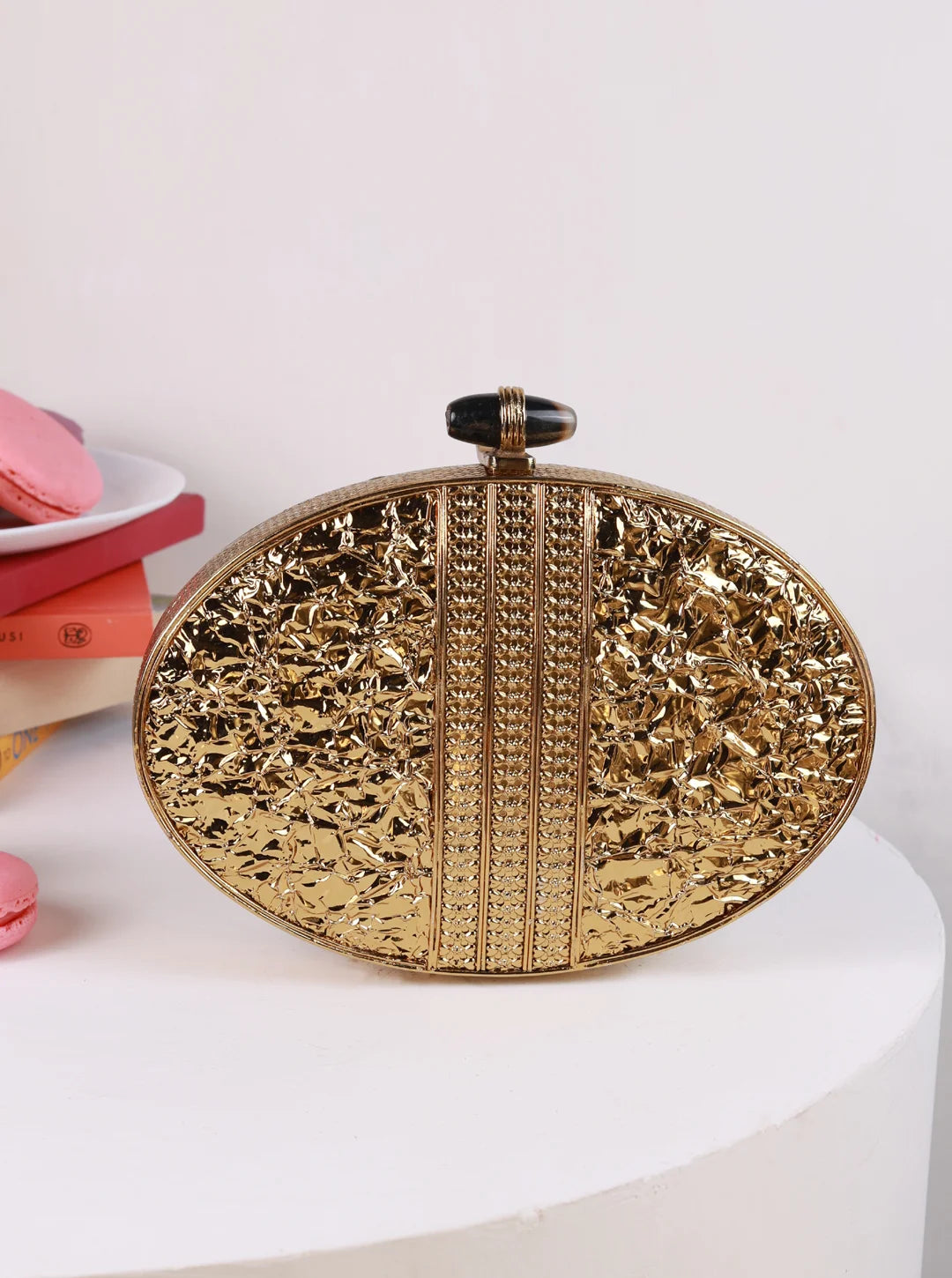 The Tan Clan Tracy Brass Clutch featuring a sleek, metallic finish and compact design, perfect for evening accessories.