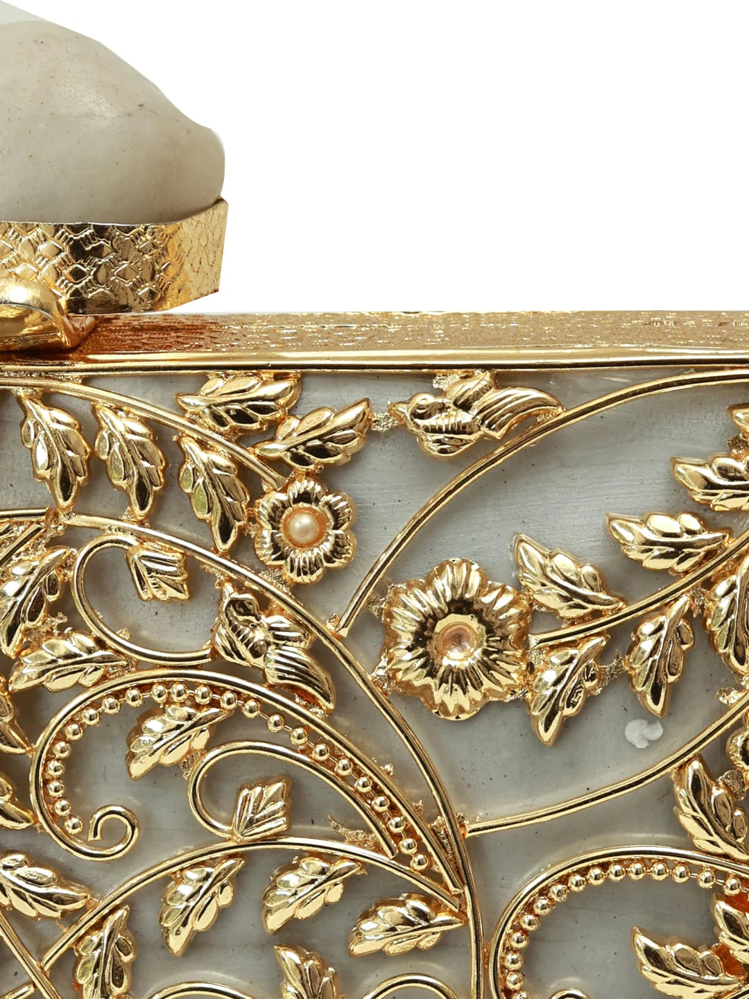 Uzma brass clutch by The Tan Clan with intricate embossed design and elegant clasp, showcasing detailed craftsmanship.