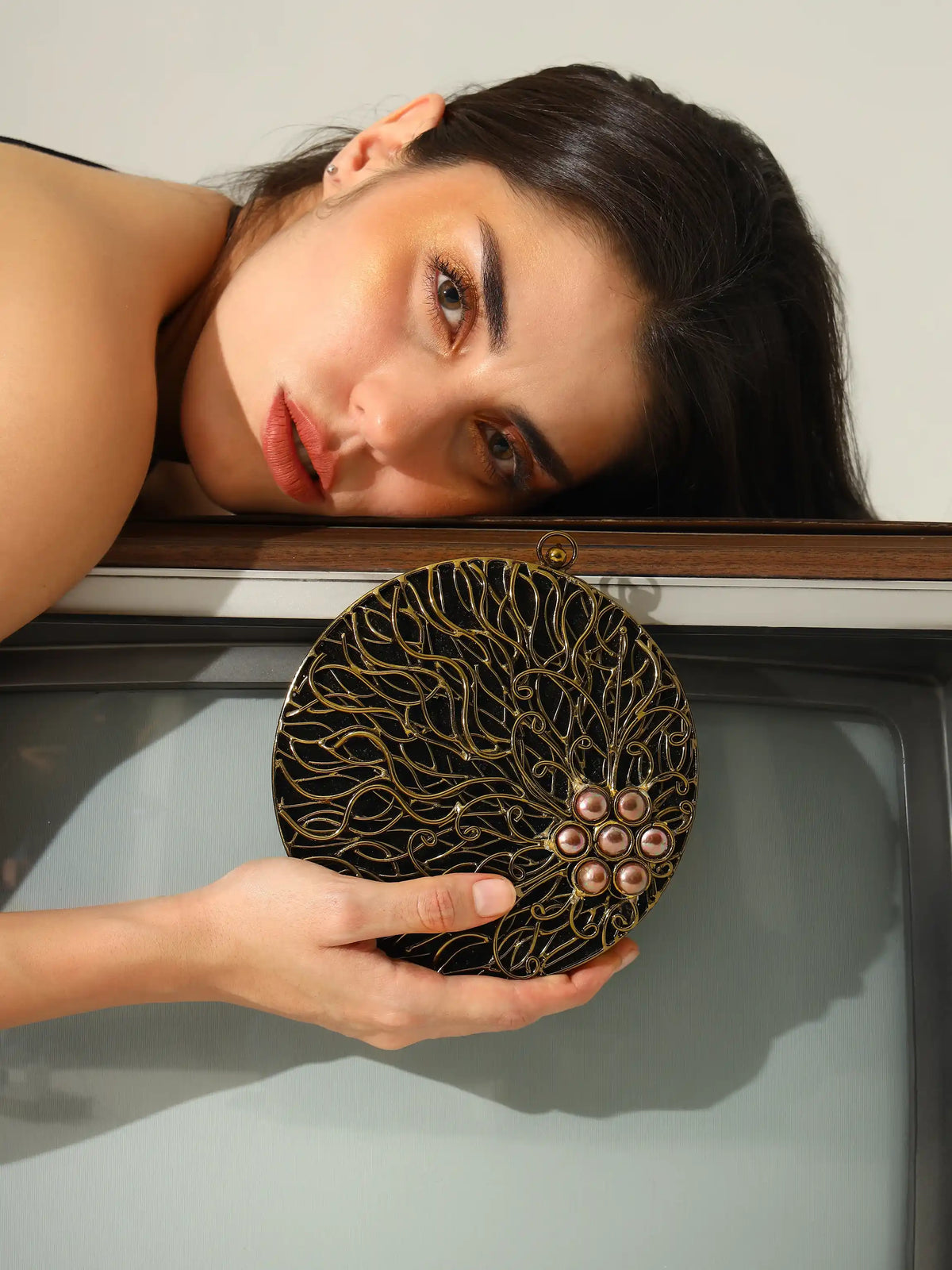 Vana Brass Clutch by The Tan Clan featuring a sleek, polished brass exterior and elegant design for stylish occasions.