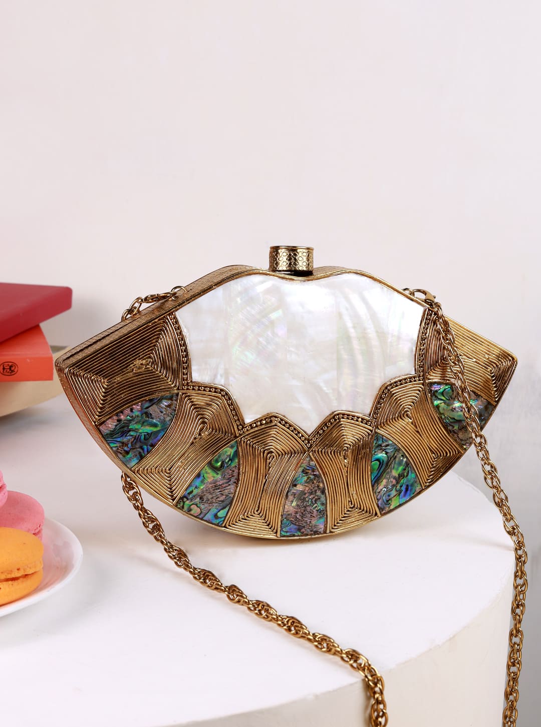 Zuri Mother of Pearl Brass Clutch by The Tan Clan featuring a sleek design with iridescent shell and brass accents.