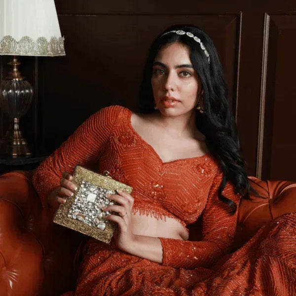 A beautifully embellished brass clutch bag with intricate details from The Tan Clan, perfect for elegant occasions.