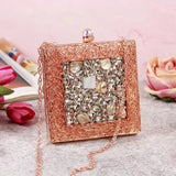A brass clutch with intricate embellishments from The Tan Clan, featuring detailed decorative patterns and a sleek, elegant design.