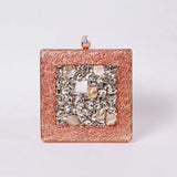 A brass clutch by The Tan Clan with intricate embellishments, featuring a sleek design and elegant craftsmanship.