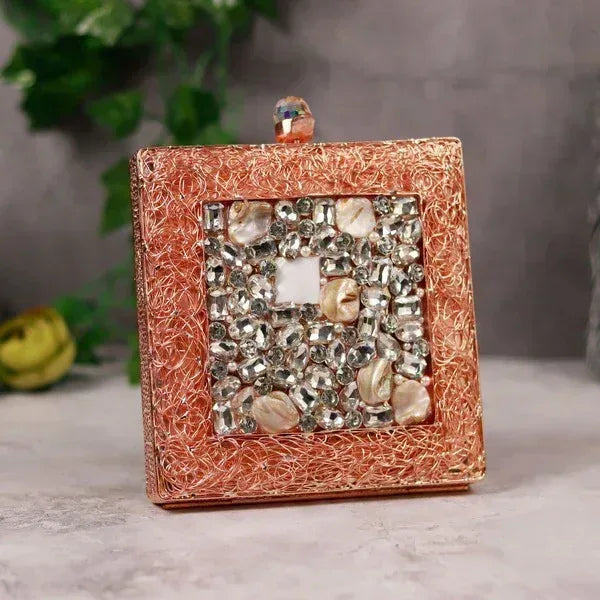 Aafreen embellished brass clutch by The Tan Clan featuring intricate designs and a polished metallic finish.