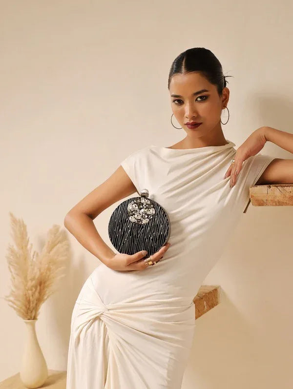 Aashna round embellished brass clutch with intricate designs, crafted by The Tan Clan, featuring a polished brass finish and decorative accents.