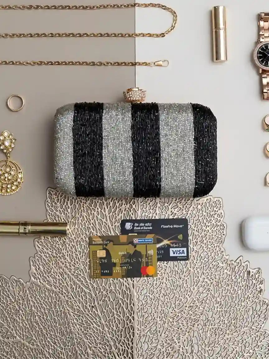 Afshaan hand-embroidered clutch bag by The Tan Clan with intricate colorful embroidery and a sleek design.