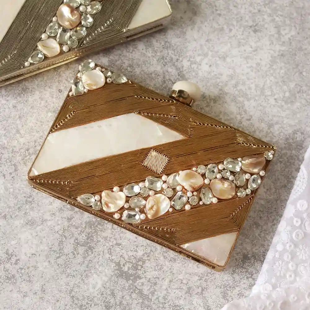 Aisha Embellished Mother of Pearl Clutch by The Tan Clan, featuring intricate embellishments and a sleek design, on a neutral background.