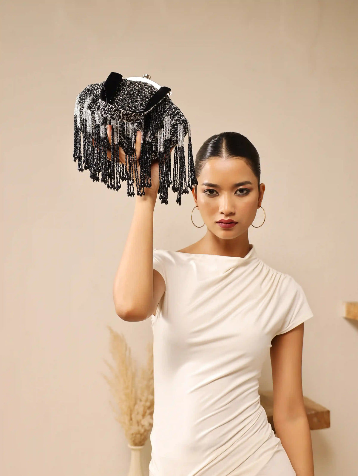 Black Batua bag by The Tan Clan with a detachable handle, featuring a sleek design and spacious interior.