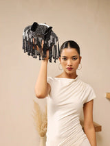 Black Batua bag by The Tan Clan with a detachable handle, featuring a sleek design and spacious interior.