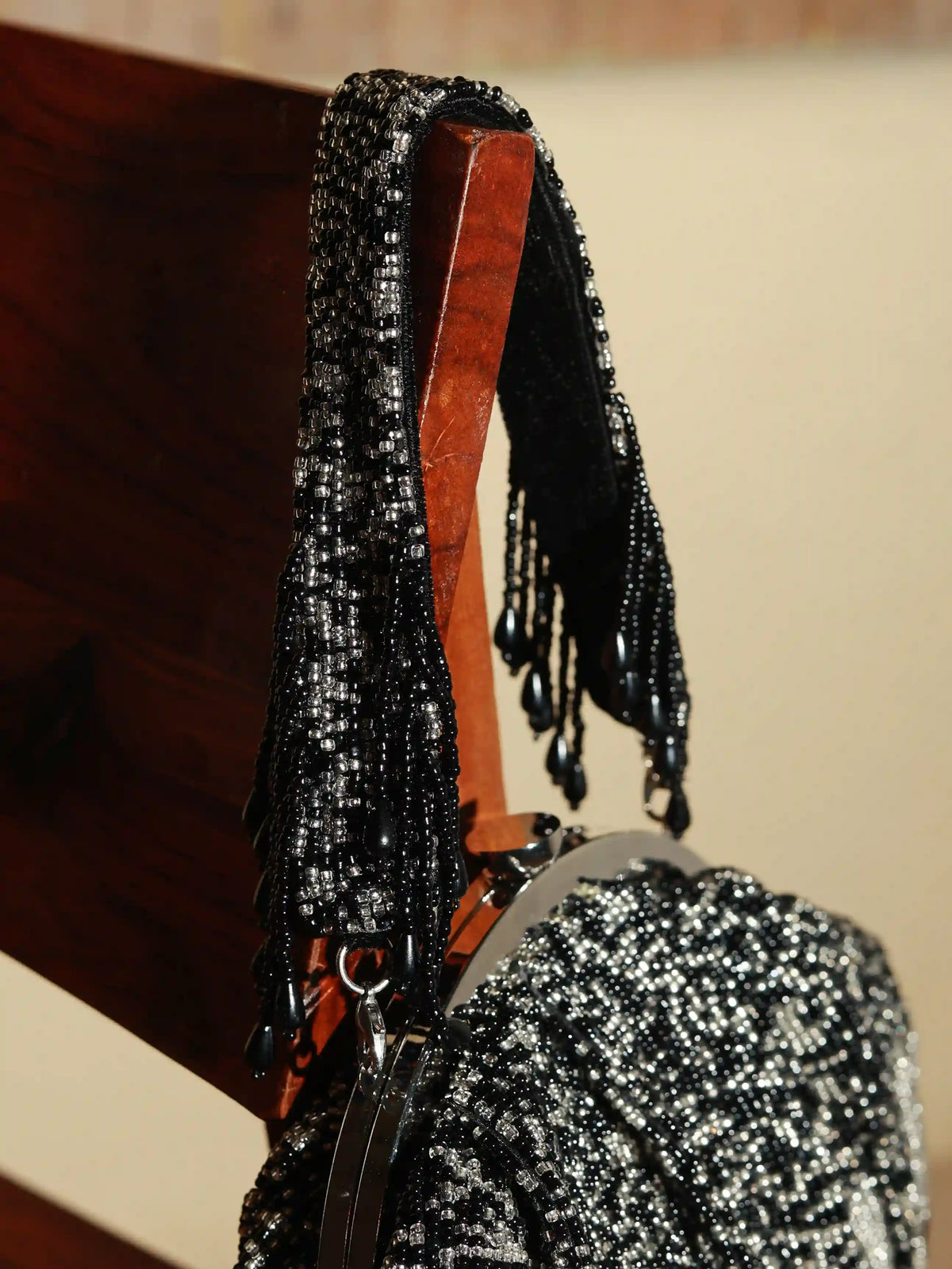 Black Batua bag with detachable handle by The Tan Clan, featuring a stylish design and spacious interior.
