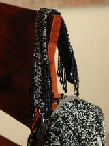 Black Batua bag with detachable handle by The Tan Clan, featuring a stylish design and spacious interior.