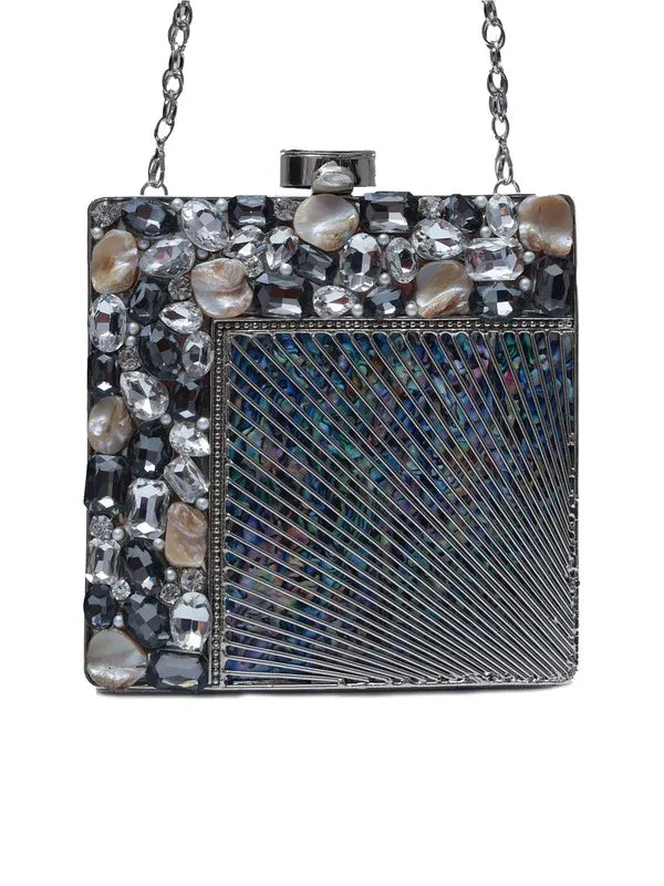 A brass clutch purse with intricate embellishments and decorative details, crafted by The Tan Clan.