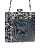 A brass clutch purse with intricate embellishments and decorative details, crafted by The Tan Clan.