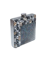 A brass clutch bag with intricate embellishments, featuring a sleek design and decorative clasp, by The Tan Clan.