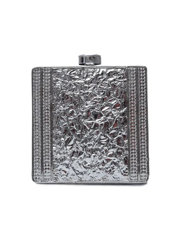 A brass clutch with intricate embellishments by The Tan Clan, featuring detailed decorative design and a sleek, elegant shape.
