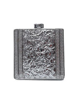 A brass clutch with intricate embellishments by The Tan Clan, featuring detailed decorative design and a sleek, elegant shape.