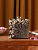 A brass embellished clutch bag with intricate detailing, designed by The Tan Clan, showcasing a stylish compact accessory.