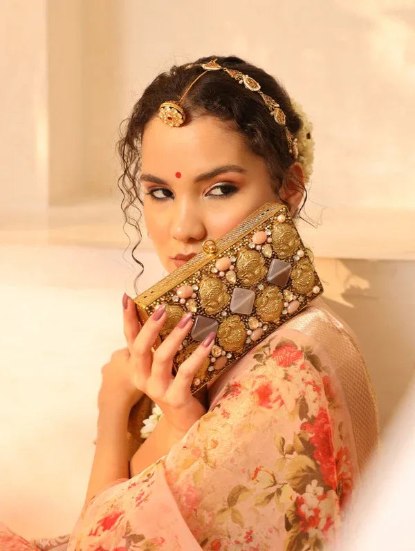 Elegant brass clutch with intricate embellishments from The Tan Clan, featuring detailed design and a sleek, compact style.