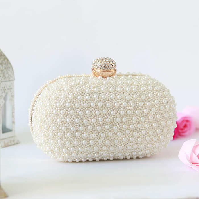 White pearl hand-embroidered clutch bag by The Tan Clan with intricate detailing and elegant design.