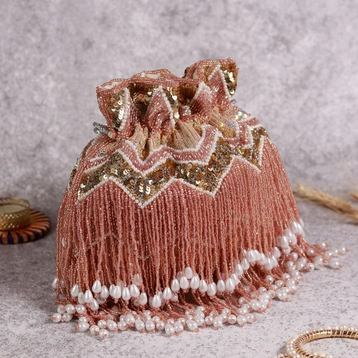 Asmi Potli bag by The Tan Clan featuring tassels and a handle, with traditional design and intricate detailing.