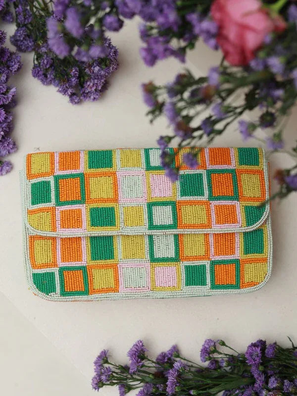 The Tan Clan Blossom Blocks Baguette Bag with handle, stylish woven bag featuring a colorful floral pattern and a sturdy handle.