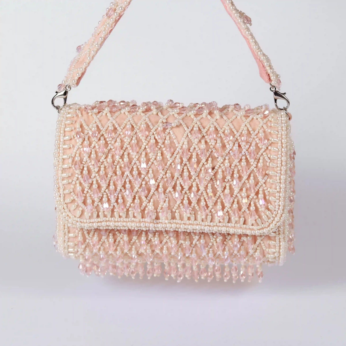 Blush flap-over bag with handle from The Tan Clan, featuring a stylish and functional design for everyday use.