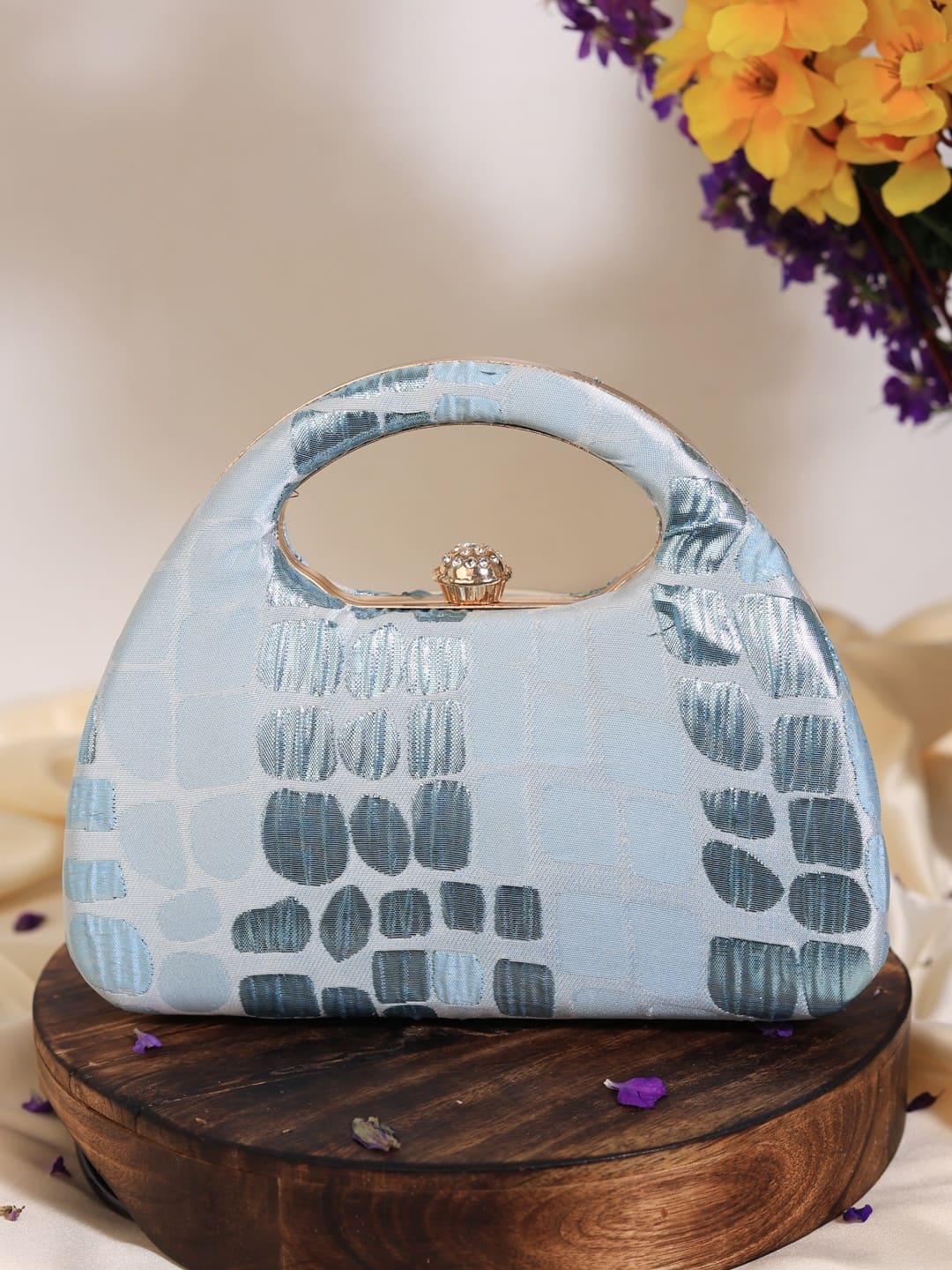 Coral Arc Blue Clutch by The Tan Clan featuring a sleek, curved design and vibrant coral blue color.