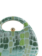 Coral Arc Green Clutch by The Tan Clan showing a stylish, curved design with a smooth finish and compact size.