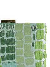 Coral sleek green clutch by The Tan Clan, featuring a compact design with a textured exterior and elegant gold-tone clasp.