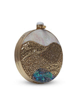 Crescent-shaped round clutch bag with mother of pearl exterior by The Tan Clan, featuring a sleek, elegant design.
