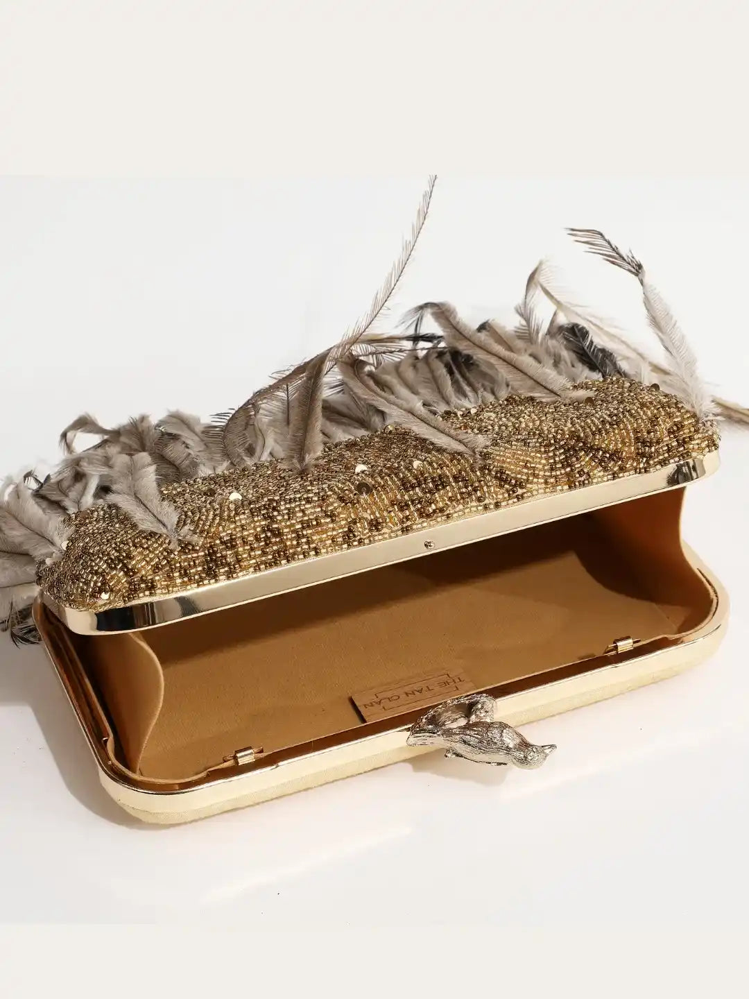 Dark gold hand-embroidered feather clutch by The Tan Clan featuring intricate embroidery and a stylish, compact design.