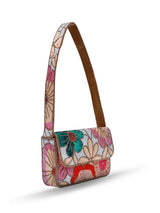 Daisy floral baguette bag with handle by The Tan Clan, featuring a colorful floral pattern and a sleek, rectangular shape.