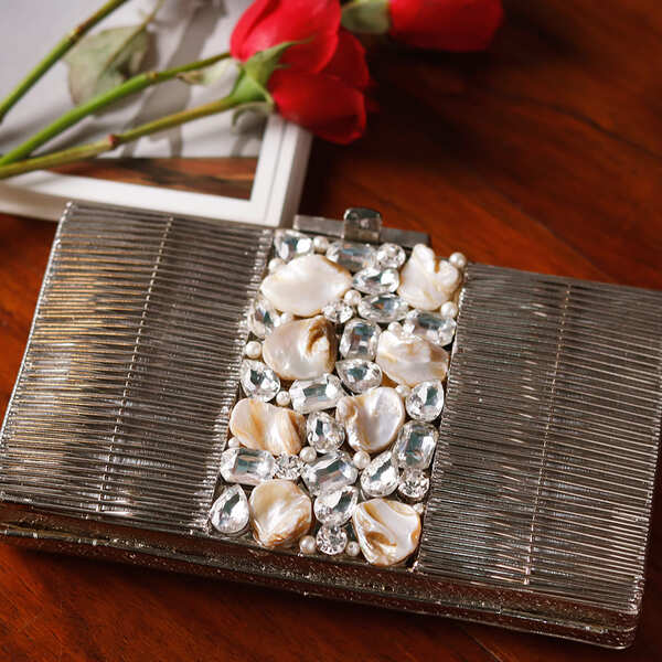 Daniya mother of pearl brass clutch by The Tan Clan, featuring a shimmering pearl design and elegant brass frame.