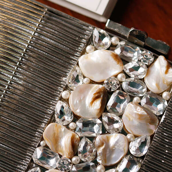 Daniya Mother of Pearl Brass Clutch by The Tan Clan featuring a sleek, elegant design with iridescent pearl accents and brass detailing.