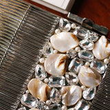 Daniya Mother of Pearl Brass Clutch by The Tan Clan featuring a sleek, elegant design with iridescent pearl accents and brass detailing.