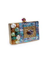 Disha Mother of Pearl Clutch by The Tan Clan featuring a shimmering pearl surface and elegant compact design.