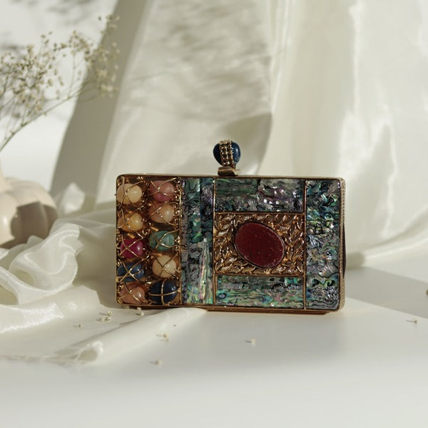 Disha Mother of Pearl Clutch by The Tan Clan featuring shimmering pearl design and elegant compact shape.
