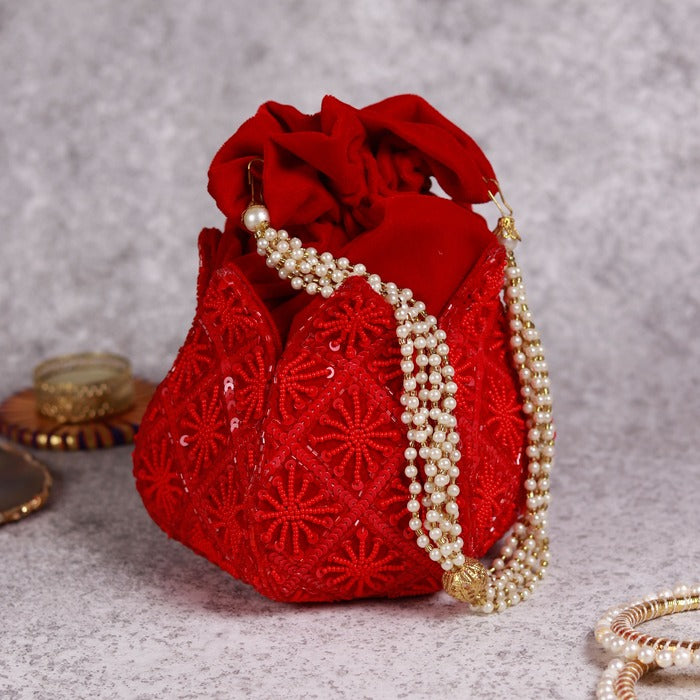 Hand-embroidered lotus design on a traditional potli bag from The Tan Clan, showcasing intricate embroidery and vibrant fabric.