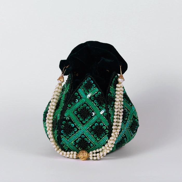 Hand embroidered lotus design on traditional potli bag by The Tan Clan, showcasing intricate embroidery and vibrant craftsmanship.