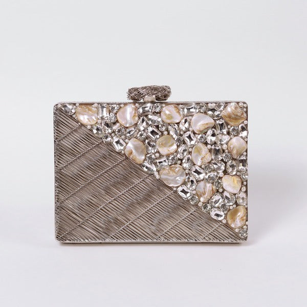 Silver brass clutch bag with intricate embellishments from The Tan Clan Eira collection, featuring a sleek, elegant design.